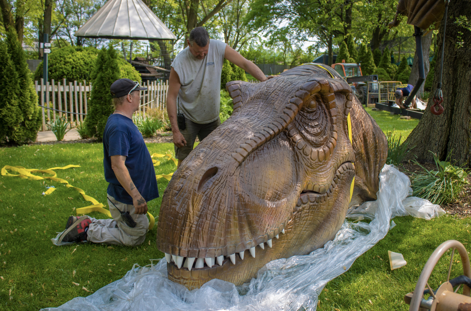 A worker assembles the head of an animatronic dinosaur. A worker assembles the head of an animatronic dinosaur.
