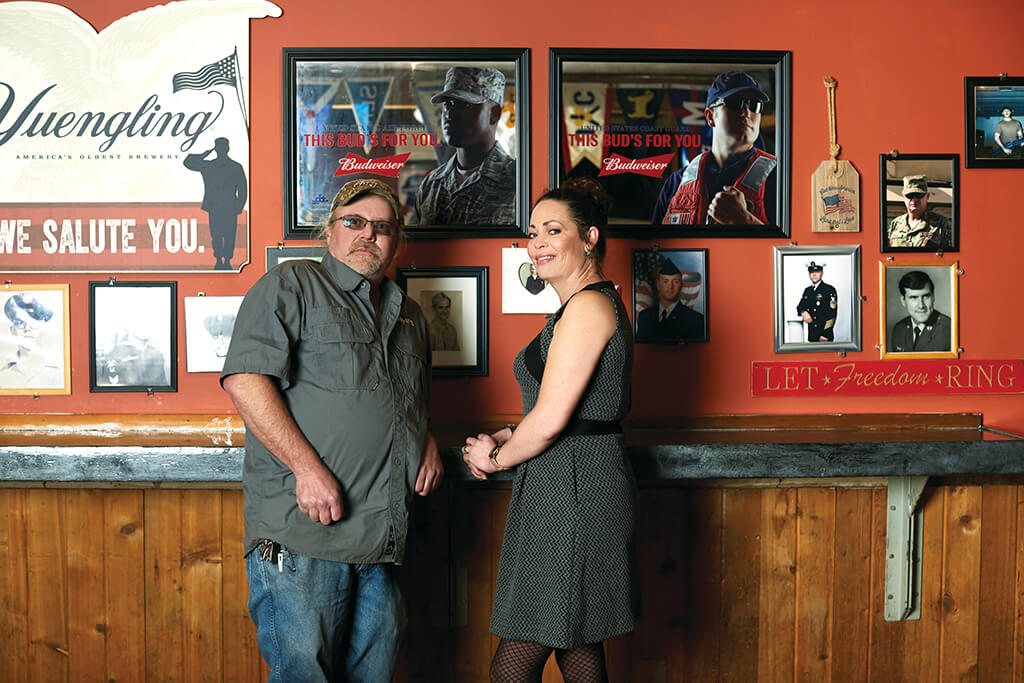 Peeper's Owners in front of Wall of Honor Peeper's Owners in front of Wall of Honor